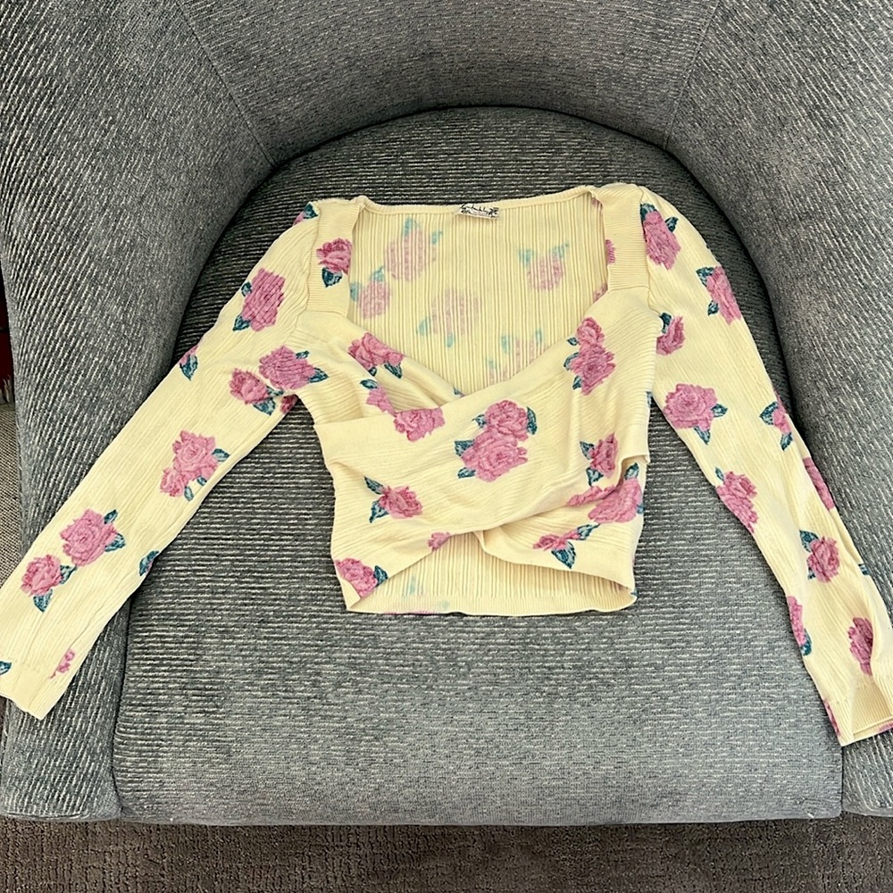 A yellow crop top with Purple flowers. Little long in the back.